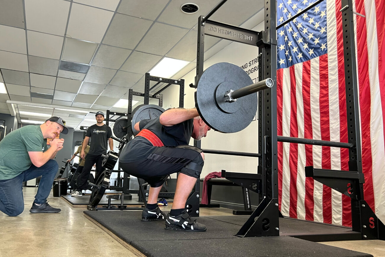 A man squatting a barbell.