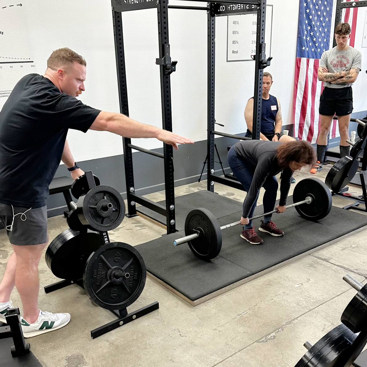 Coach guiding a member through a deadlift at The Strength Co.