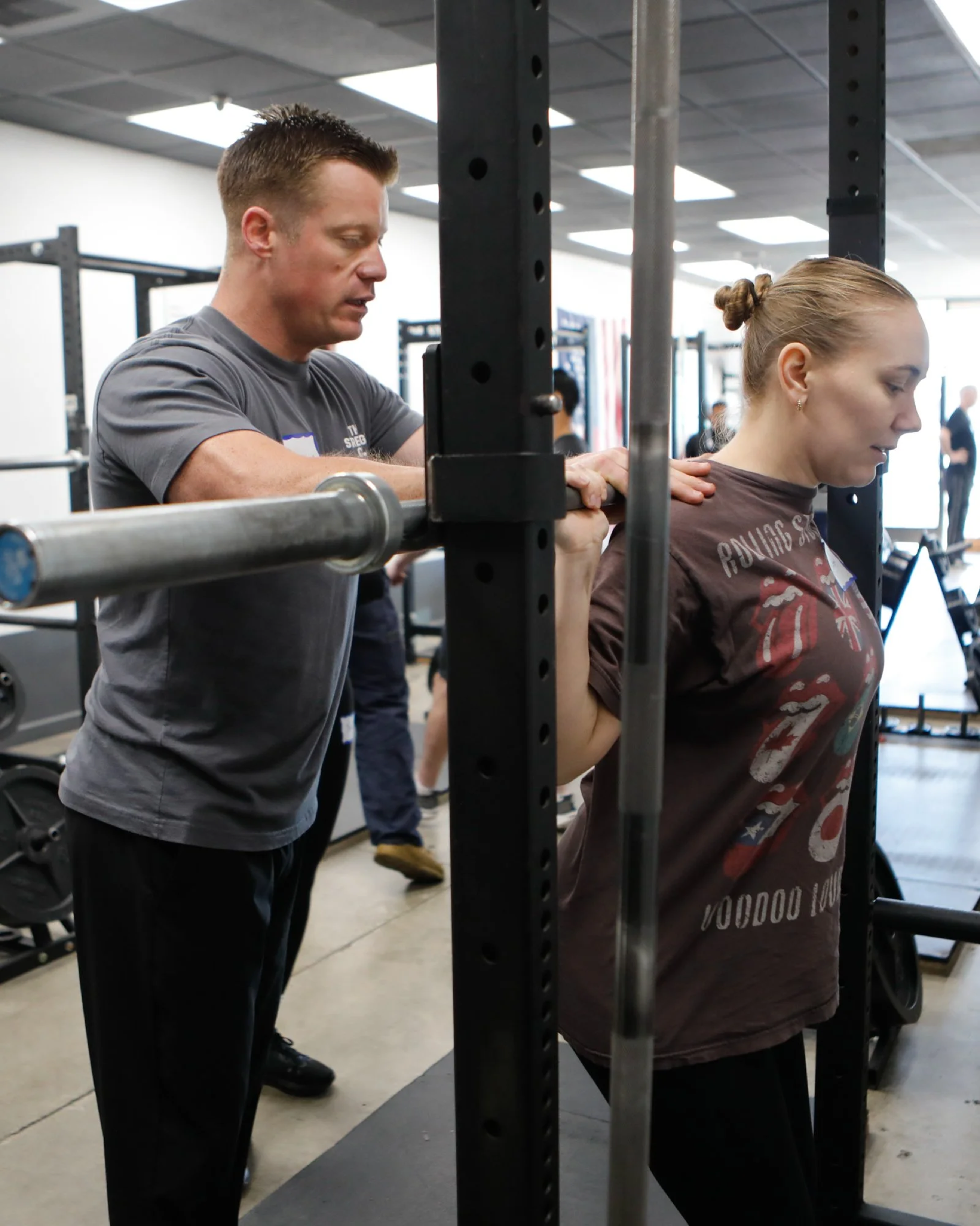 Coach spotting a member at the squat rack
